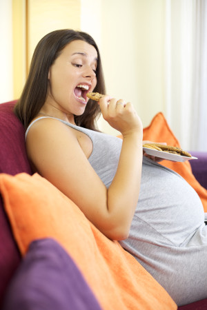 Mujer embarazada comiendo galletas
